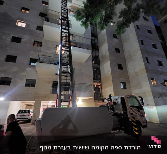 מנוף מרים ספה לבניין מגורים גבוה בלילה